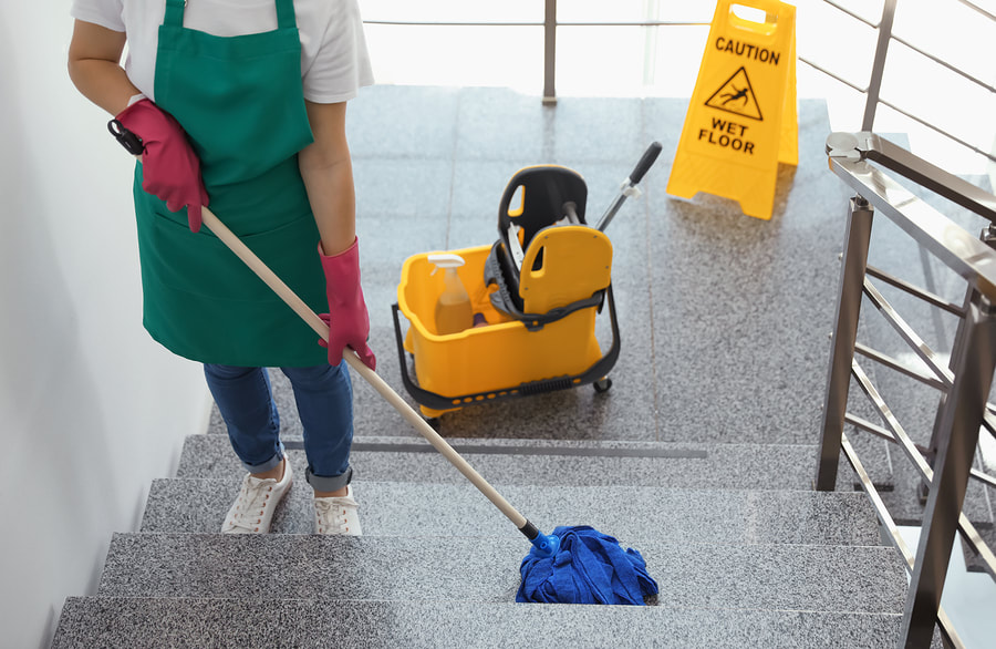 a woman cleaning the stairs with a mop